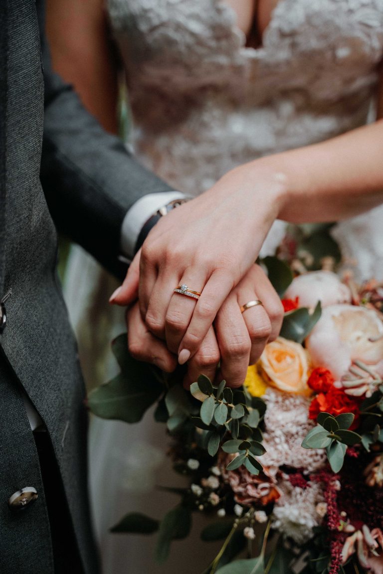 Wedding photo of hands with rings and flowers